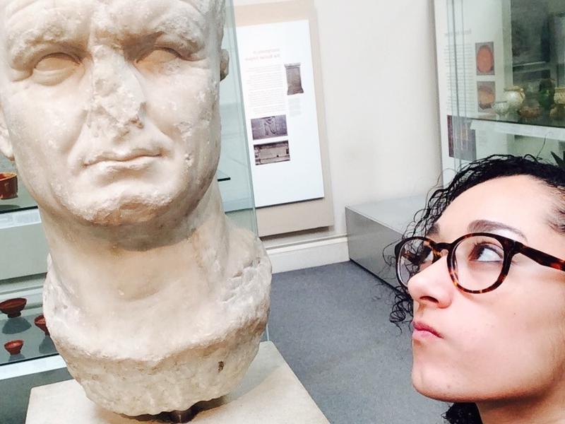 Student wrinkling her nose at a marble bust with a missing nose